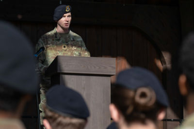 security forces officer standing at podium talking to group of people
