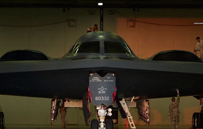 image of an aircraft in a hangar with maintainers working on it